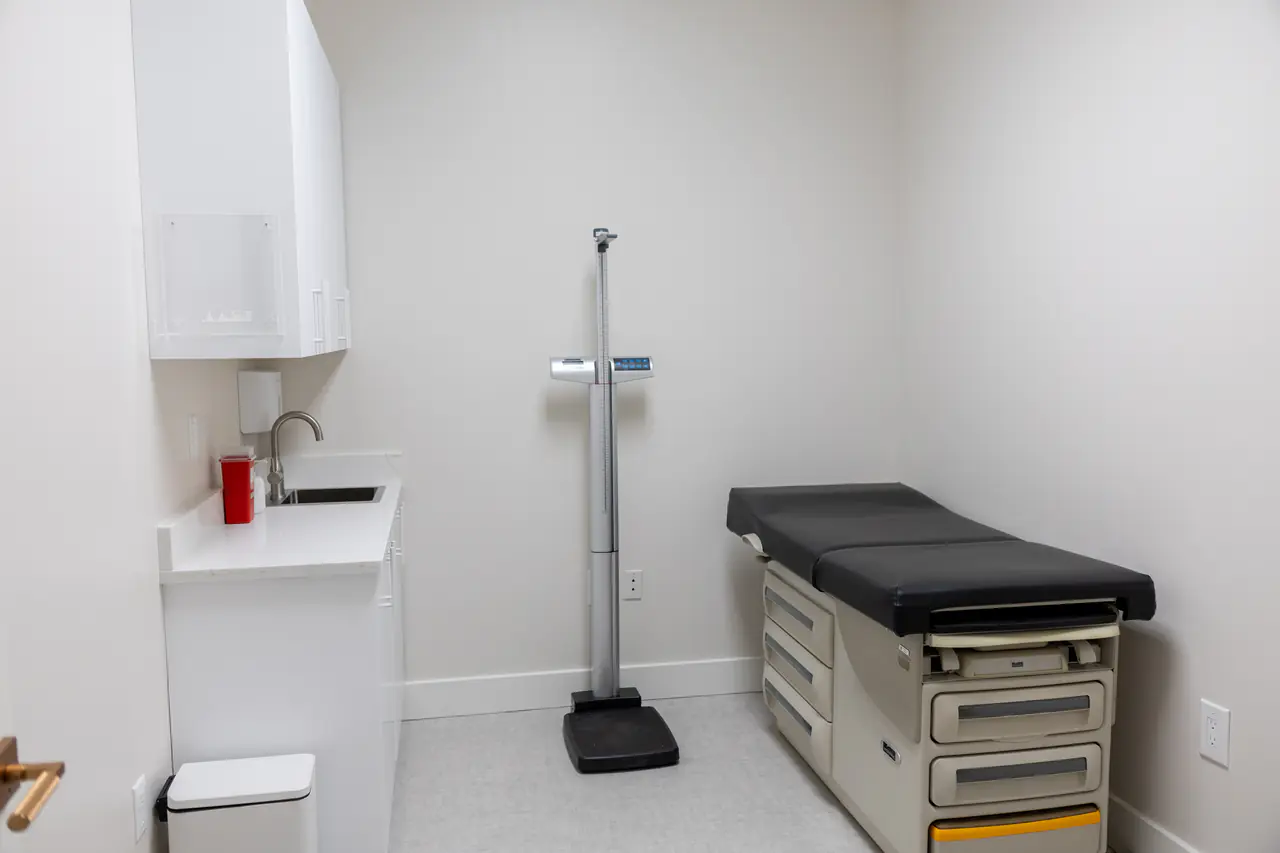 Photograph of a Fenix exam room with a scale and exam table; no people