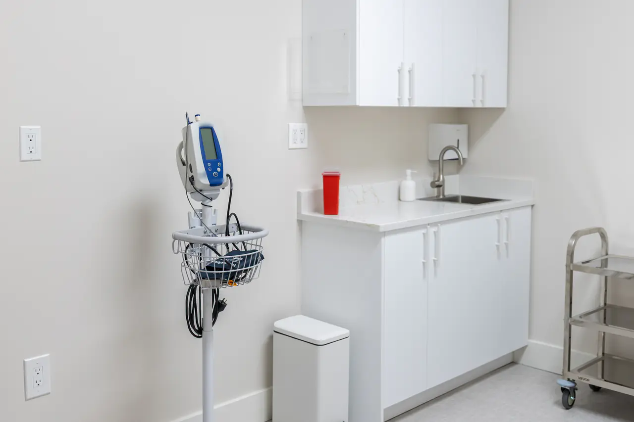 Photograph of a Fenix examination room with a vital-signs monitor and cabinets; no people