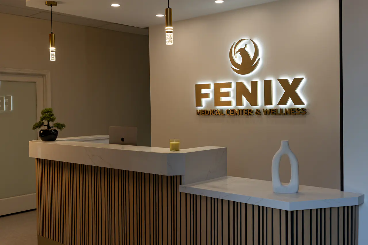 Photograph of the Fenix reception with the illuminated sign above the desk; no people