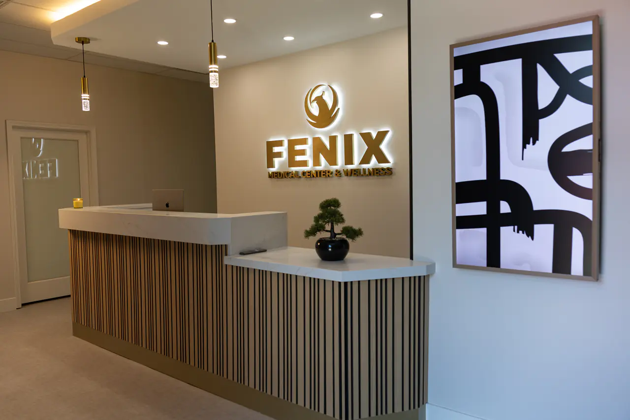 Photograph of the Fenix desk with the sign and a black-and-white artwork; no people